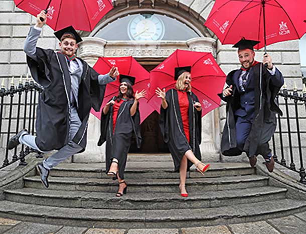 Graduates celebrating with red umbrellas